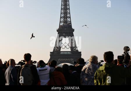 Pékin, France. 7 juin 2024. Les gens regardent les anneaux olympiques sur la Tour Eiffel, à Paris, France, le 7 juin 2024. Les anneaux olympiques sont dévoilés sur la Tour Eiffel tôt le matin de vendredi alors que la capitale française marque 50 jours avant le début des prochains Jeux Olympiques de Paris 2024. Crédit : Gao Jing/Xinhua/Alamy Live News Banque D'Images