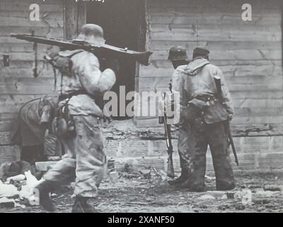 Photo B&W de la seconde Guerre mondiale les soldats allemands recherchent des traînards russes après être entrés dans une ville à l'hiver 1944 Banque D'Images