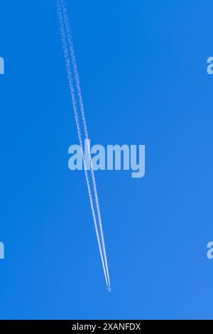 Le ciel bleu traîne depuis un avion de ligne à réaction volant à haute altitude, dans le centre de Victoria, en Australie. Banque D'Images