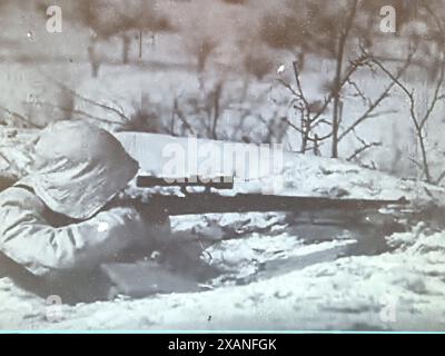 Capture d'écran de la seconde Guerre mondiale en noir et blanc. Soldat allemand avec fusil de sniper en camouflage de neige pendant l'hiver 1941/42 sur le front russe. Banque D'Images