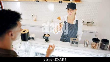 Femme, crème glacée et client avec service, gelato et sourire avec donner dessert au restaurant. Aider, serveur et serveuse avec travailler dans pour Banque D'Images