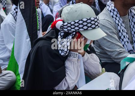 Bandung, Java occidental, Indonésie. 8 juin 2024. Une femme qui pleure couvre son visage avec une écharpe palestinienne pendant un long march en solidarité avec les Palestiniens à Bandung, en Indonésie. Ils ont exigé la fin des attaques israéliennes qui ont provoqué le génocide à Gaza et Rafah en Palestine. (Crédit image : © Dimas Rachmatsyah/ZUMA Press Wire) USAGE ÉDITORIAL SEULEMENT! Non destiné à UN USAGE commercial ! Banque D'Images