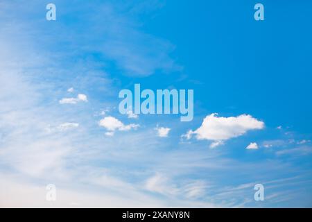 Ciel bleu clair avec quelques nuages moelleux. Fond bleu naturel Banque D'Images