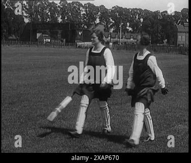 Deux femmes civiles portant des gymnases et des tampons tenant des chauves-souris de cricket dans un terrain de jeu, années 1920 De "Time to Remember - Teenage Flapper", années 1920 (Reel 1) ; un dcumentaire sur la vie des femmes dans les années 1920 - grand commentaire de Joyce Grenfell. Banque D'Images