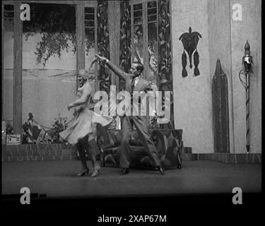 Scène d'un spectacle de scène : hommes et femmes civils dansant sur une scène dans une routine avec beaucoup de remontées mécaniques et beaucoup de coups de pied élevés, 1929. "Ce danseur aux longues pattes est Cyril Ritchard". De "Time to Remember - 1929 le temps de la Maison à Bognor" - Reel 4 ; un documentaire sur le monde en 1929. Maladie du roi George V &amp ; dépression économique. Banque D'Images