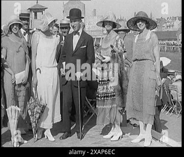 Civils portant des tenues intelligentes et des chapeaux posant pour la caméra pendant une course de chevaux, dans les années 1920 De "Time to Remember - Teenage Flapper", années 1920 (Reel 2) ; un dcumentaire sur la vie des femmes dans les années 1920 - grand commentaire de Joyce Grenfell. Banque D'Images
