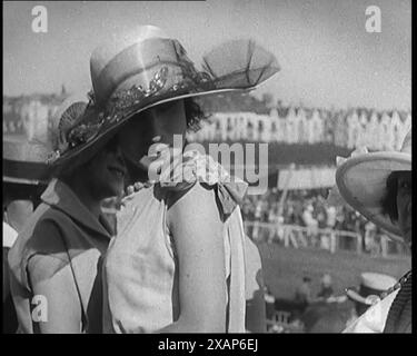 Trois femmes civiles portant des tenues et des chapeaux d'été intelligents discutant à la course de chevaux, dans les années 1920 De "Time to Remember - Teenage Flapper", années 1920 (Reel 2) ; un dcumentaire sur la vie des femmes dans les années 1920 - grand commentaire de Joyce Grenfell. Banque D'Images