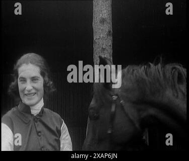 Une femme civile portant une tenue de Jockey enlevant son chapeau devant son cheval et souriant à la caméra, dans les années 1920 De "Time to Remember - Teenage Flapper", années 1920 (Reel 3) ; un dcumentaire sur la vie des femmes dans les années 1920 - grand commentaire de Joyce Grenfell. Banque D'Images