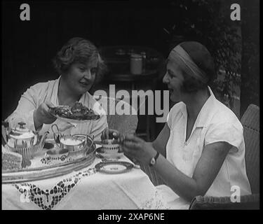 Betty May Nuthall Shoemaker, meilleure joueuse de tennis féminine au monde britannique, buvant du thé avec une civile féminine, dans les années 1920 De "Time to Remember - Teenage Flapper", années 1920 (Reel 4) ; un dcumentaire sur la vie des femmes dans les années 1920 - grand commentaire de Joyce Grenfell. Banque D'Images