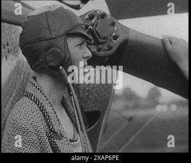 L'aviatrice américaine Amelia Mary Earhart portant un casque devant un avion, dans les années 1920 De "Time to Remember - Teenage Flapper", années 1920 (Reel 4) ; un dcumentaire sur la vie des femmes dans les années 1920 - grand commentaire de Joyce Grenfell. Banque D'Images