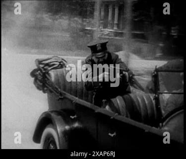 Des policiers américains masculins sur une voiture tirant sur une Gunmachine sur persue [sic], années 1930 Officier de police tirant une mitrailleuse alors qu'il poursuivait des criminels. De "Time to Remember - The Tough Guys", années 1930 (Reel 1) ; un film documentaire principalement sur la vie dans la dépression et les gangsters américains. Banque D'Images