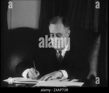 Le président Franklin d Roosevelt signe des papiers derrière un bureau, années 1930 Le président Roosevelt signe "un projet de loi autorisant la vente de bière et de vins. La dernière piqûre de gangstérisme a été tirée avec la fin de la prohibition. De "Time to Remember - The Tough Guys", années 1930 (Reel 2) ; film documentaire, principalement sur la vie dans la dépression et les gangsters américains. Banque D'Images