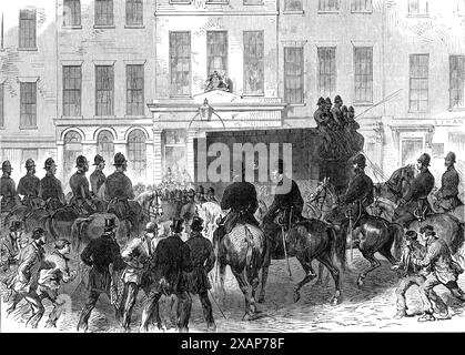 Les prisonniers féniens au tribunal de police de Bow-Street : retrait des prisonniers du palais de justice, 1868. 'Les cinq personnes en garde à vue sur l'accusation de meurtre volontaire fait en faisant sauter le mur de la maison de détention de Clerkenwell le 13 décembre, étaient à nouveau brought...before Sir Thomas Henry... leurs noms sont Timothy Desmond et William Desmond, frères; Jeremiah Allen, Nicholas English et Ann Justice... les prisonniers ont été transportés de Millbank dans un fourgon-prison ordinaire, escortés par un fort détachement de la police montée, armés de cutlass et de revolvers, et alors que le véhicule passait à travers la rue Banque D'Images