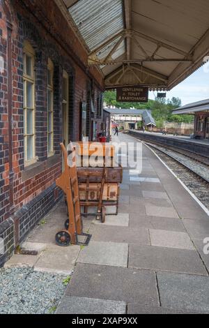 Vieilles valises en cuir et en toile empilées sur les chariots de la gare ferroviaire au quai de la gare ferroviaire de Llangollen, Llangollen, pays de Galles. Banque D'Images