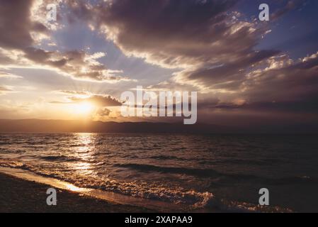 Spectaculaire coucher de soleil coloré sur la mer Méditerranée. Ciel avec des rayons de soleil. Fond de Cloudscape nature. Banque D'Images