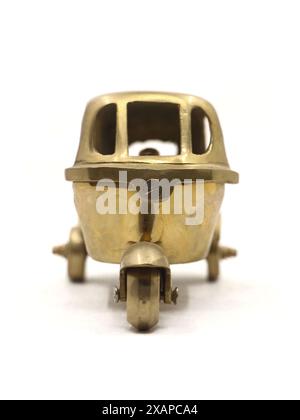 un modèle de jouet vintage d'un véhicule rikshaw automatique à trois roues fabriqué en laiton doré métal isolé en blanc Banque D'Images
