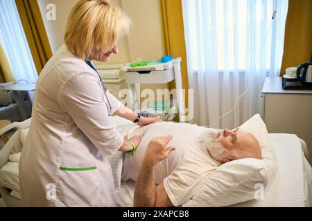 Patient adulte allongé sur un lit pendant un examen Banque D'Images