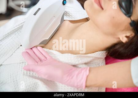 Femme sous luminothérapie pulsée intense en clinique de médecine esthétique Banque D'Images
