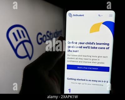Personne tenant le téléphone portable avec la page Web de la société autrichienne de technologie de l'éducation GoStudent GmbH devant le logo. Concentrez-vous sur le centre de l'écran du téléphone. Banque D'Images