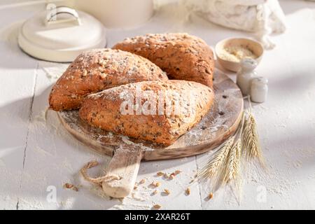 Rouleaux triangulaires sains et frais faits de levain et de farine. Brioches triangulaires cuites dans une boulangerie. Banque D'Images