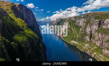 Une vue panoramique sur un fjord en Norvège, avec des falaises imposantes, une végétation luxuriante et un plan d'eau bleu et calme. Kjerag, Lysebotn, Lysefhjorden, Norvège Banque D'Images