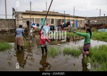 Une famille a vu pêcher devant leurs maisons après la montée des eaux du lac Naivasha dans le comté de Nakuru. La montée du niveau du lac Naivasha a déplacé plus de 5 000 personnes dans le domaine de Kihoto, à environ 90 km au nord-ouest de Nairobi, la capitale du Kenya. Ces maisons ont été submergées en raison de l'augmentation des précipitations au cours des deux derniers mois, ce qui a entraîné une élévation du niveau d'eau du lac. Le Département météorologique du Kenya a prédit que davantage de pluie continuerait à tomber et que la situation des inondations pourrait s'aggraver. Banque D'Images