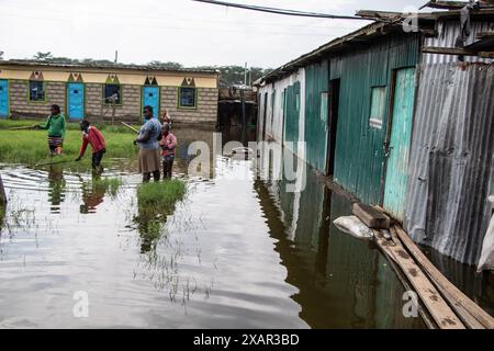 Une famille a vu pêcher devant leurs maisons après la montée des eaux du lac Naivasha dans le comté de Nakuru. La montée du niveau du lac Naivasha a déplacé plus de 5 000 personnes dans le domaine de Kihoto, à environ 90 km au nord-ouest de Nairobi, la capitale du Kenya. Ces maisons ont été submergées en raison de l'augmentation des précipitations au cours des deux derniers mois, ce qui a entraîné une élévation du niveau d'eau du lac. Le Département météorologique du Kenya a prédit que davantage de pluie continuerait à tomber et que la situation des inondations pourrait s'aggraver. Banque D'Images