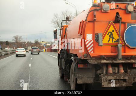 Appareil de récolte. Transport spécial pour le nettoyage dans la ville. Camion orange. Flotte de véhicules du service public de la ville. Banque D'Images