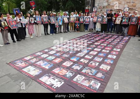 Des militants portant des photos de leurs proches disparus prennent part à la manifestation. La branche de Diyarbakir de l'Association turque des droits de l'homme (IHD) et les proches des Kurdes disparus ont organisé la 800ème semaine de la "que les personnes disparues soient retrouvées et que les auteurs soient jugés", ils ont protesté devant le monument du droit à la vie dans le parc Kosuyolu à Diyarbakir. Depuis 15 ans, des familles se rassemblent dans ce parc, exigeant que les corps de leurs proches disparus pour des raisons politiques soient retrouvés et que leurs assassins soient jugés. Banque D'Images