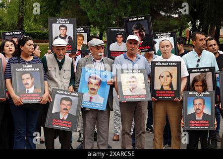 Des militants portant des photos de leurs proches disparus vus pendant la manifestation. La branche de Diyarbakir de l'Association turque des droits de l'homme (IHD) et les proches des Kurdes disparus ont organisé la 800ème semaine de la "que les personnes disparues soient retrouvées et que les auteurs soient jugés", ils ont protesté devant le monument du droit à la vie dans le parc Kosuyolu à Diyarbakir. Depuis 15 ans, des familles se rassemblent dans ce parc, exigeant que les corps de leurs proches disparus pour des raisons politiques soient retrouvés et que leurs assassins soient jugés. Banque D'Images