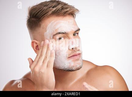 Beauté, soins de la peau ou homme avec lavage du visage en studio pour le traitement du visage, le toilettage ou la dermatologie sur fond blanc. Bien-être, cosmétique et modèle pour Banque D'Images