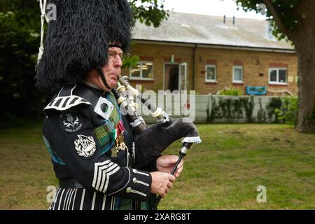 Pipe Major Diederik de Jaeger lors de la cérémonie de dévoilement du Monument de la paix, le 8 juin 2024 à Hythe, Kent, Royaume-Uni. Le dévoilement du monument a été fait par John Astor, troisième baron de Hever. Banque D'Images