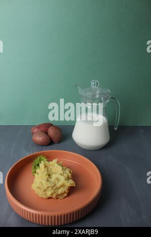 Purée de pommes de terre sur une assiette pichet de lait sur fond gris concept végétarien. Banque D'Images