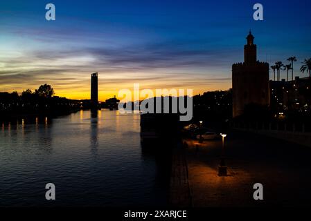 Magnifique coucher de soleil sur le fleuve Guadalquivir avec la silhouette de Torre del Oro et le pont Triana à Séville, Espagne. Banque D'Images