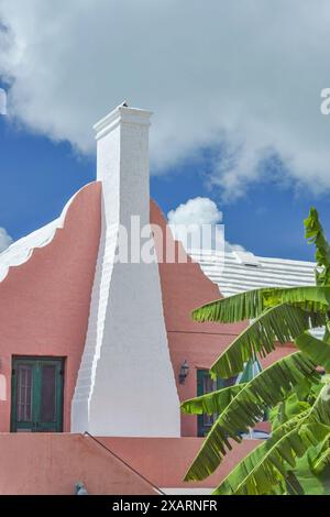 Détail de Light Coral Bermuda House avec volets verts et cheminée blanche et toit Banque D'Images