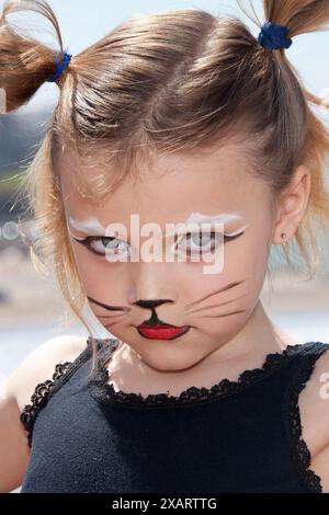 petite fille sérieuse avec maquillage de chat Banque D'Images