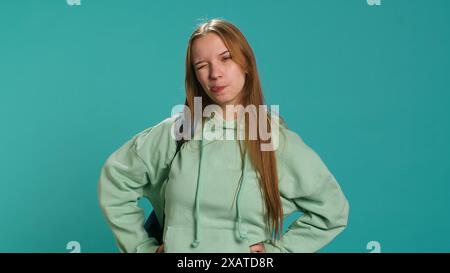 Jeune actrice qui fait du goofing, qui change d'émotions, essaie différentes expressions faciales, pratique pour les cours de théâtre, fond de studio. Adolescente faisant des visages stupides, caméra A. Banque D'Images