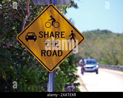 Miami, Floride, États-Unis - 13 avril 2024 : Partagez la route en gros plan avec des icônes de voitures, de vélos, de randonneurs et de motards et de véhicules entrants. Uniquement Banque D'Images