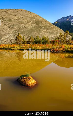 Un étang rempli d'eau de ruissellement à la base du gros tas de résidus de la mine d'amiante abandonnée à Cassiar (Colombie-Britannique) Banque D'Images