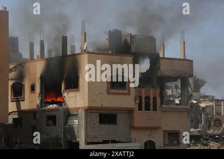 Gaza. 8 juin 2024. Cette photo prise le 8 juin 2024 montre des bâtiments endommagés lors des attaques israéliennes dans le camp de réfugiés de Nuseirat dans le centre de la bande de Gaza. Samedi, les forces israéliennes ont secouru quatre otages du camp de réfugiés de Nuseirat, dans le centre de la bande de Gaza, où, selon des sources palestiniennes, une attaque israélienne sanglante a eu lieu, tuant au moins 210 personnes et en blessant plus de 400 autres. Crédit : Marwan Daoud /Xinhua/Alamy Live News Banque D'Images