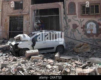 Gaza. 8 juin 2024. Cette photo prise le 8 juin 2024 montre un bâtiment et un véhicule endommagés lors des attaques israéliennes dans le camp de réfugiés de Nuseirat dans le centre de la bande de Gaza. Samedi, les forces israéliennes ont secouru quatre otages du camp de réfugiés de Nuseirat, dans le centre de la bande de Gaza, où, selon des sources palestiniennes, une attaque israélienne sanglante a eu lieu, tuant au moins 210 personnes et en blessant plus de 400 autres. Crédit : Marwan Daoud /Xinhua/Alamy Live News Banque D'Images