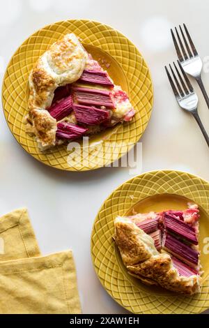 Portions de rhubarbe maison et galette de crème anglaise, sur une surface légère. Banque D'Images