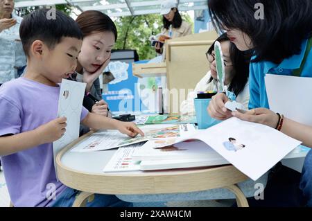 (240609) -- BEIJING, 9 juin 2024 (Xinhua) -- Une mère et son fils participent à une activité parents-enfants lors d'une campagne publique tenue à Beijing, capitale de la Chine, le 7 juin 2024. Une nouvelle campagne publique a été lancée conjointement vendredi par le Fonds des Nations Unies pour l'enfance (UNICEF) et le Centre pour la santé des femmes et des enfants de la Commission nationale de la santé (NHC) et d'autres partenaires pour donner aux enfants le meilleur départ dans la vie. La campagne, connue sous le nom de « parent with Purpose, Nurture Their future », vise à sensibiliser à l'importance du développement de la petite enfance (DPE) et à équiper les parents et Banque D'Images