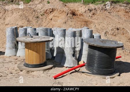 Bobines avec câble électrique d'alimentation et piliers en béton sur un chantier de construction Banque D'Images