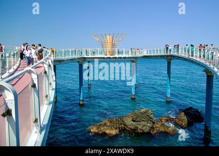 Donghae, Corée du Sud - 18 mai 2024 : les touristes marchent le long de la passerelle de l'observatoire Dojebigol Haerang, qui s'étend au-dessus de la mer de l'est, fournissant des cascades Banque D'Images