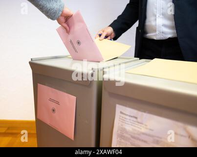 Rottweil, Allemagne. 09 juin 2024. Une femme jette une enveloppe de bulletin de vote pour les élections locales dans les urnes d'un bureau de vote du district de Rottweiler à Göllsdorf. Outre les élections européennes, des élections locales sont également organisées dans le Bade-Württemberg. Crédit : Silas Stein/dpa/Alamy Live News Banque D'Images