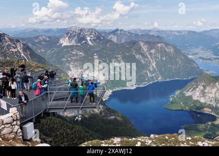 Obertraun, Autriche. 20 mai 2024. Le 20.05.2024, les visiteurs se tiennent debout sur les doigts de la plate-forme d'observation à 5 doigts sur le Krippenstein, une montagne de 2108 mètres de haut à la limite nord des montagnes du Dachstein dans la municipalité d'Obertraun en haute-Autriche (Autriche), et regardent sur le panorama montagneux. En arrière-plan, le lac Hallstatt avec le village de Hallstatt s’étend au milieu de la vue panoramique sur le paysage montagneux du Salzkammergut haute-Autriche. Crédit : Matthias Balk/dpa/Alamy Live News Banque D'Images