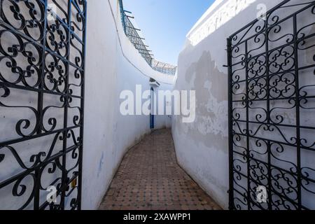 Une étroite ruelle blanche et des portes ouvertes en fer forgé à Rabat, la capitale du Maroc en Afrique du Nord Banque D'Images