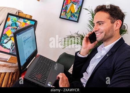 Masculin Urban Professional jeune adulte et professionnel gay travaillant avec son ordinateur portable et son smartphone dans un café pour aider ses clients avec leur marketing en ligne et seo. Berlin, Allemagne. MRYES Berlin les verts, le café et les plantes berlin Allemagne Copyright : xGuidoxKoppesx Banque D'Images