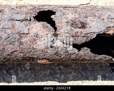 surface du tuyau en acier avec des trous à la suite de la corrosion gros plan sur la journée ensoleillée Banque D'Images